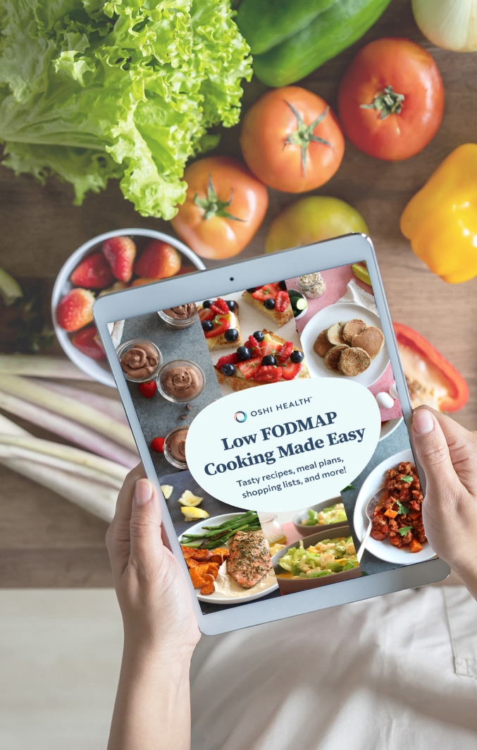 Hands holding tablet with cover of Low FODMAP Cooking Made Easy cookbook