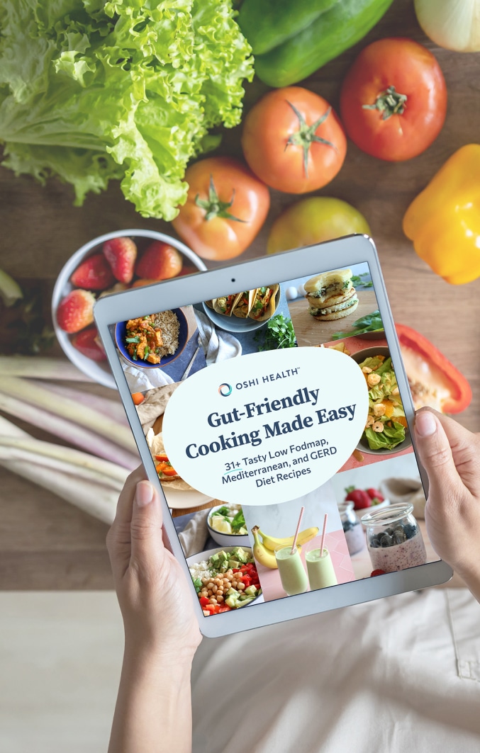 Hands holding tablet with cover of Gut-Friendly Cooking Made Easy cookbook